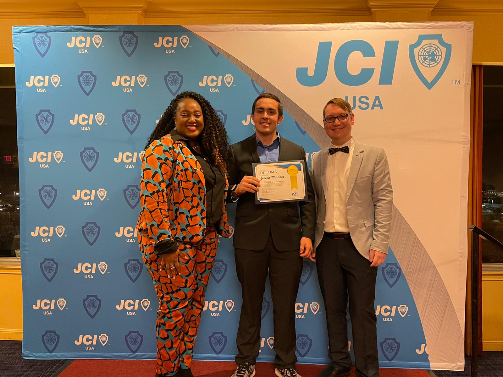 A North American Academy graduate posing with his graduation certificate.